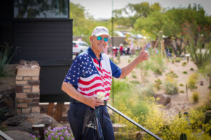 a golfer at tee it up for the troops standing and giving a thumbs up the camera while at tee it up for the troops