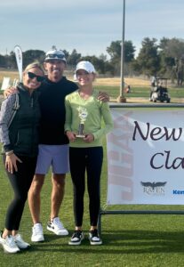 addy taylor holding a trophy and smiling with her mom and dad at one of her tournaments