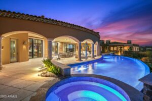 a pool in arizona at desert mountain club that is lit up at night