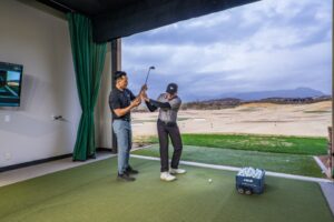 shot of dk kim, golf professional at desert mountain club, helping a member at the jim flick golf performance center