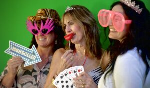 three women standing and smiling with silly sunglasses at a teammate event at desert mountain club, which was just honored with a fourth straight great place to work certification