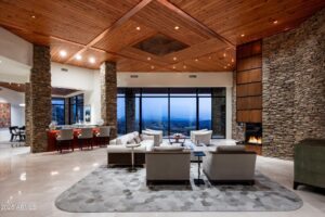 large living area at a luxury home at desert mountain club showing large wooden ceilings and stone walls