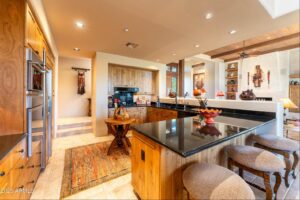 interior shot of a kitchen with southwestren themed art inside a new listing home with a club membership at desert mountain club