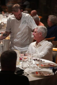 a chef in a white top talking with a member after a dining event at desert mountain club