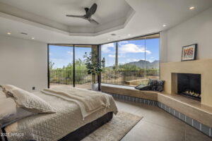 a scottsdale home bedroom at desert mountain looking out at the desert scenery with a fireplace