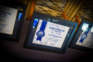 a blue zone certificate set in a black frame on a black table that shows desert mountain club as a certified blue zone community