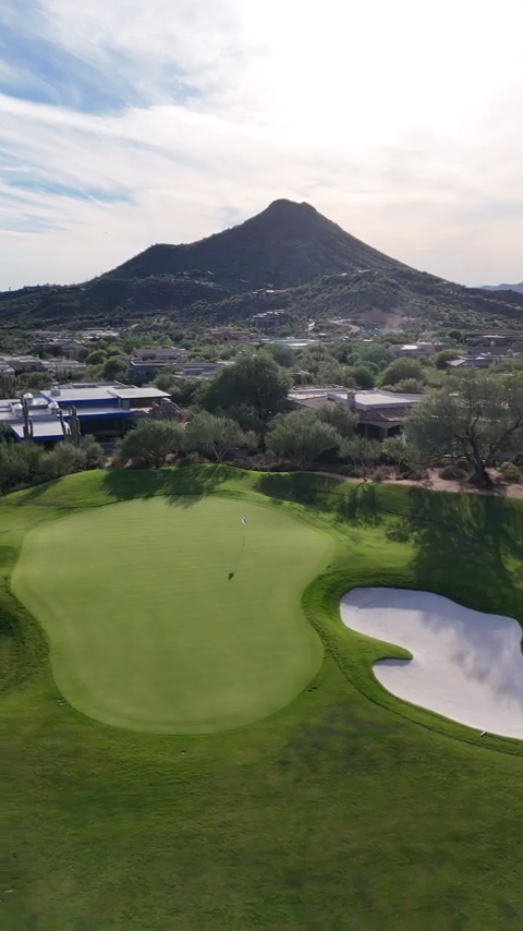 drone shot of a green at geronimo golf course with lone mountain in the backdrop