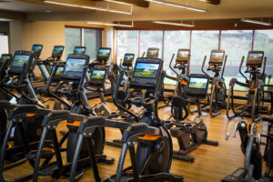 shot of the fitness floor at desert mountain club showing stationary bikes and cycles overlooking desert views